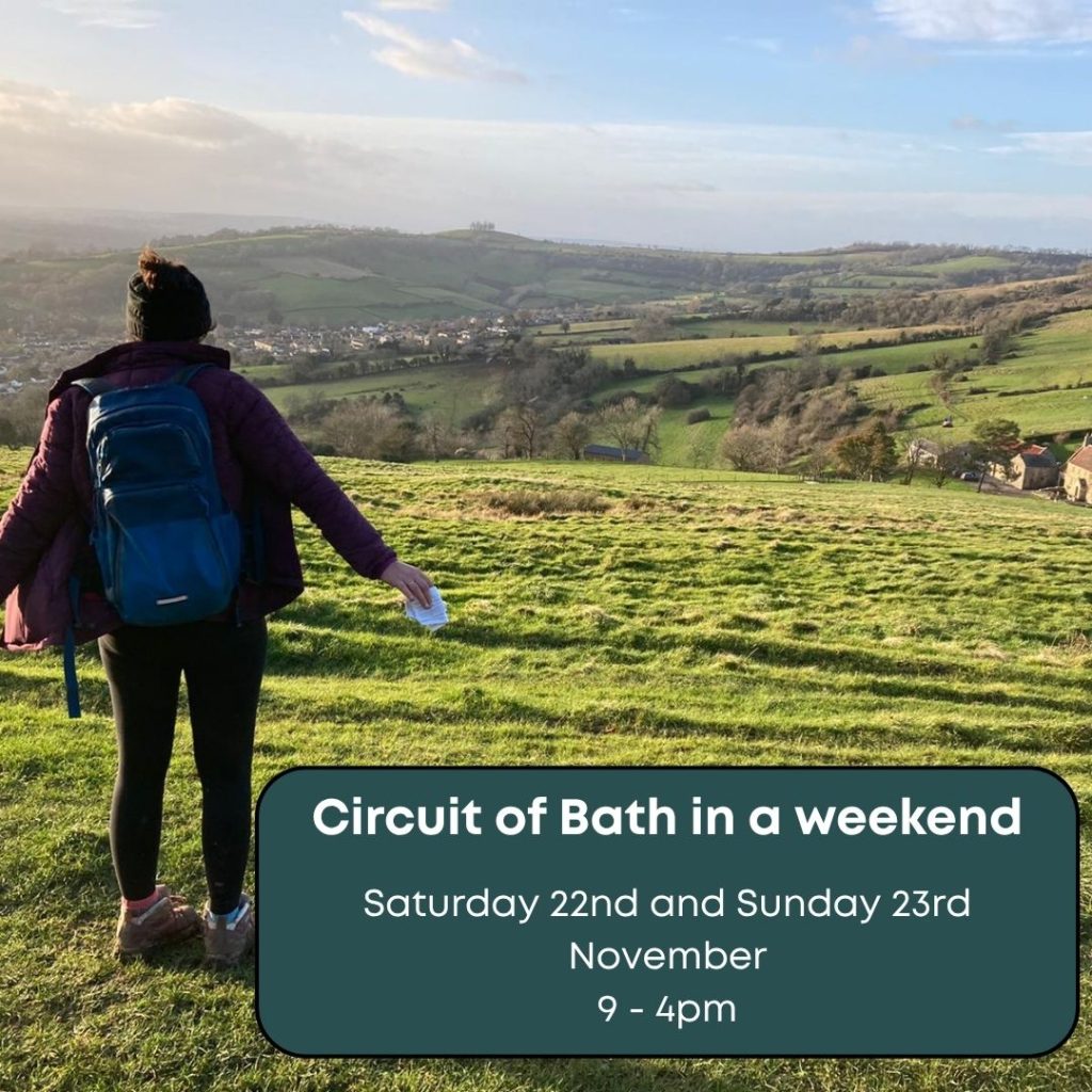 Image of a person dressed in outdoor clothing looking out over a field into a view of a green landscape